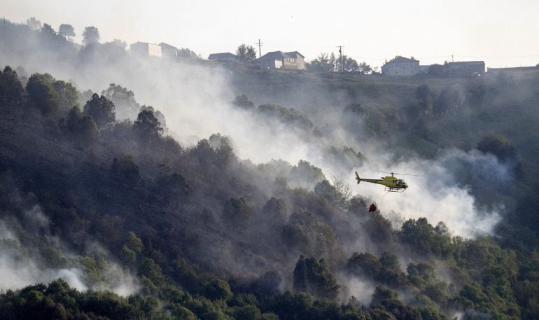 Un helicóptero durante las labores de extinción del incendio que sigue activo en la parroquia de Vilarello, Lugo.