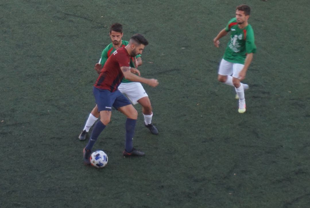 Fran Hernández controla el balón ante dos rivales