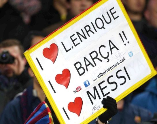 Un seguidor del FC Barcelona muestra una pancarta de apoyo a Messi y Luis Enrique