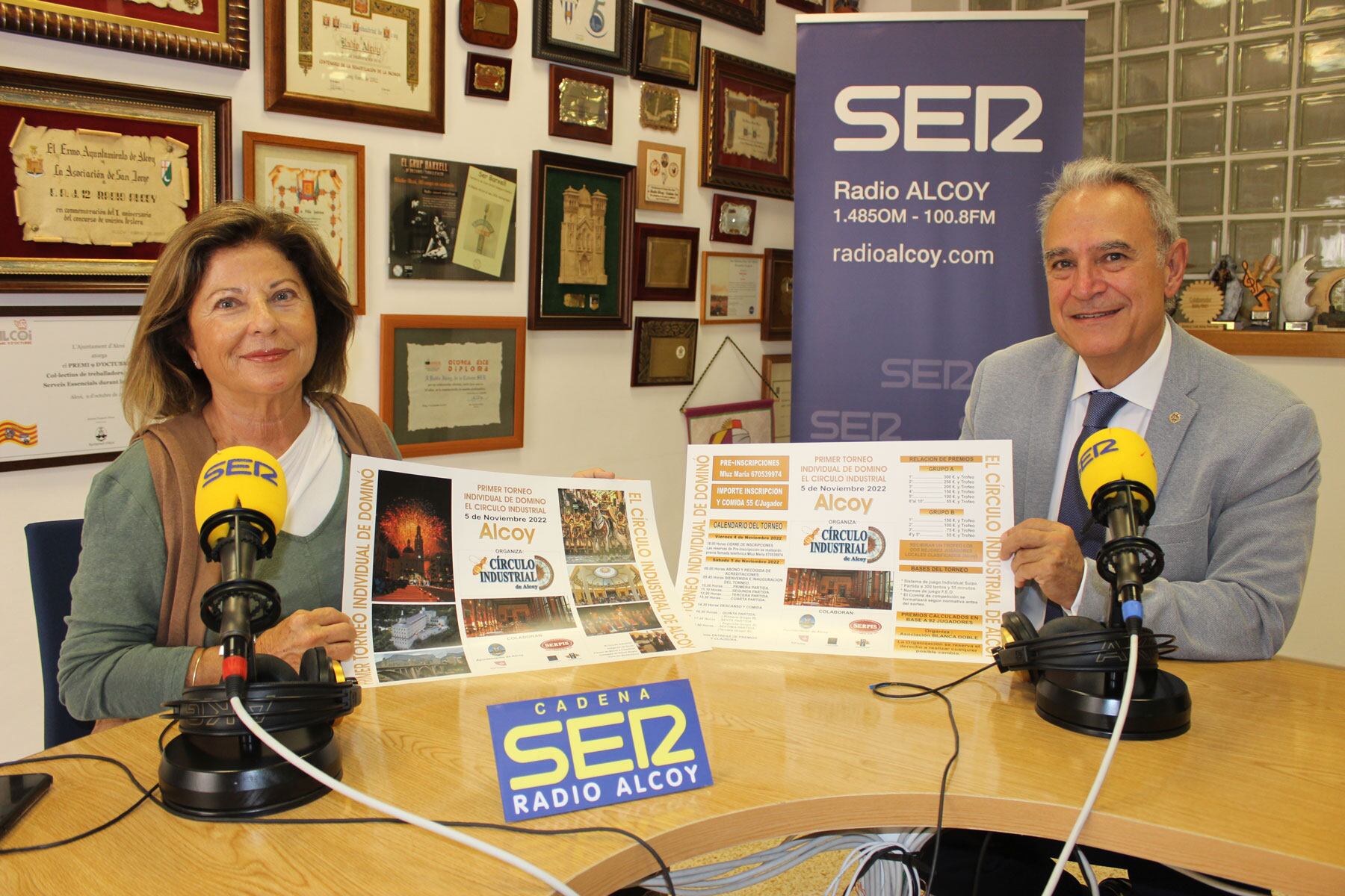 Mari Luz María e Indalecio Carbonell en el estudio central de Radio Alcoy muestran los carteles que anuncian este campeonato