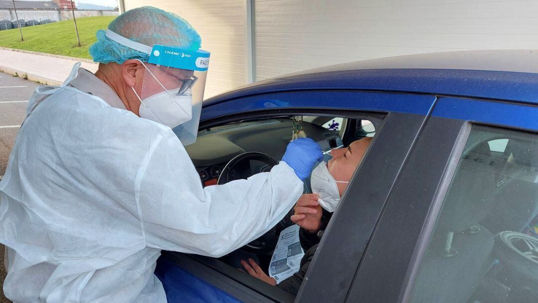 Un sanitario realiza un test de antígenos a un usuario desde su coche. 