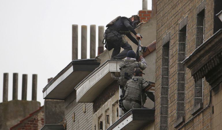 Fuerzas especiales belgas se encaraman a un bloque de viviendas durante una redada antiterrorista en el barrio bruselense de Molenbeek.