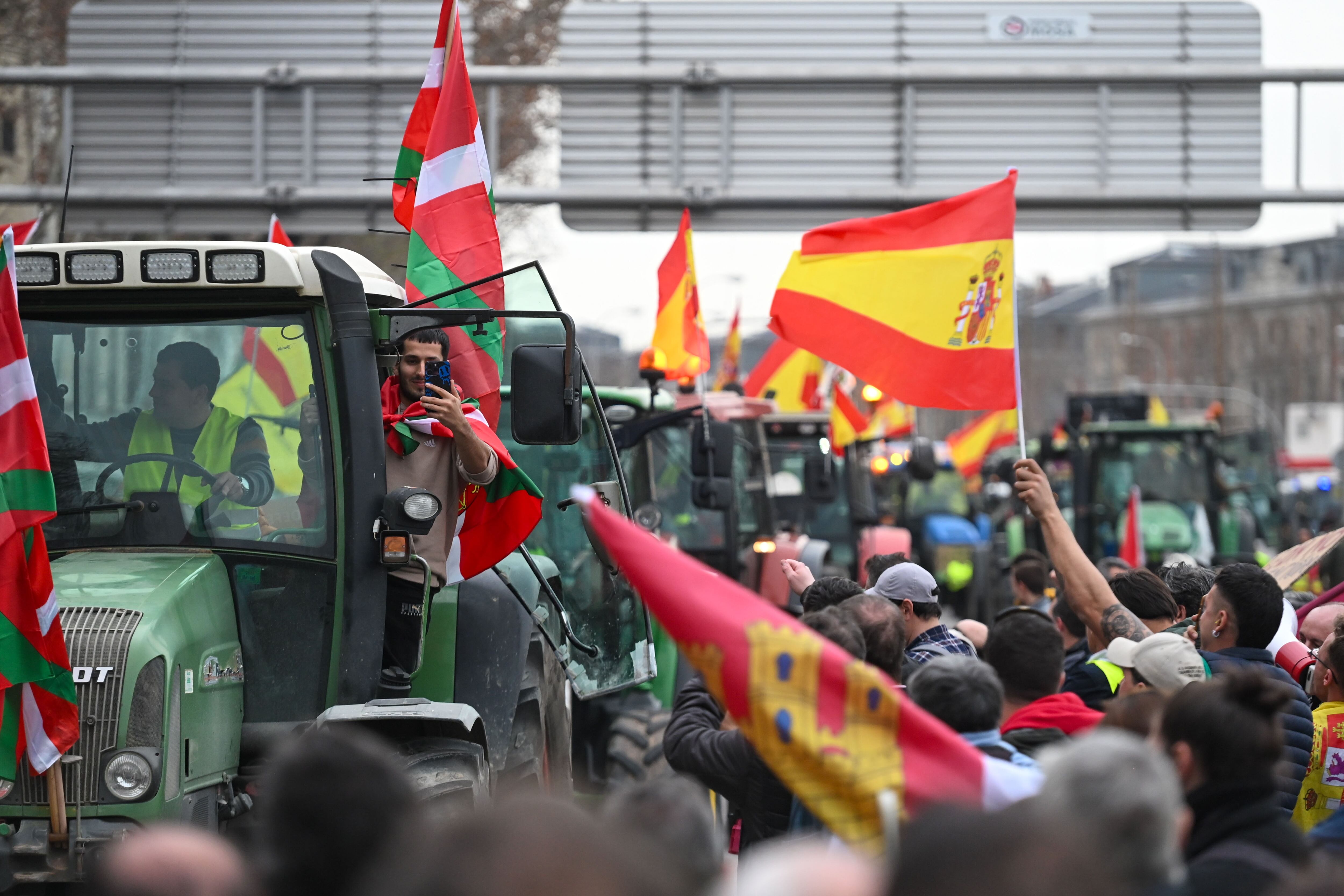 MADRID, 21/02/2024.- Decenas de personas reciben una caravana de tractores durante una protesta que tiene como principales reivindicaciones la fijación de precios justos en el campo, la revisión de la Política Agraria Común (PAC) y la reciprocidad en las relaciones comerciales, este miércoles en Madrid. EFE/ FERNANDO VILLAR
