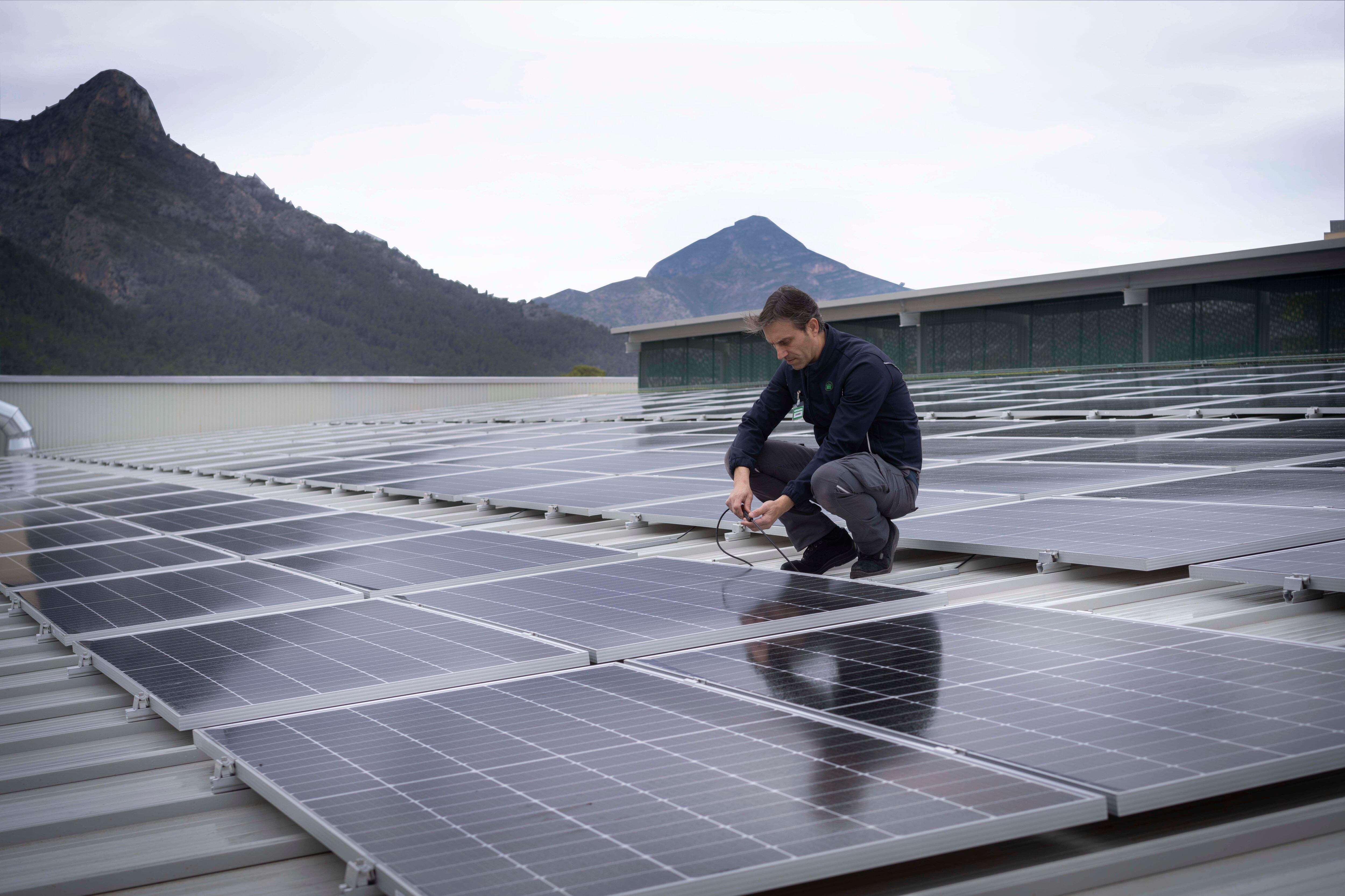 Trabajador de Mercadona en una cubierta de una tienda con paneles solares