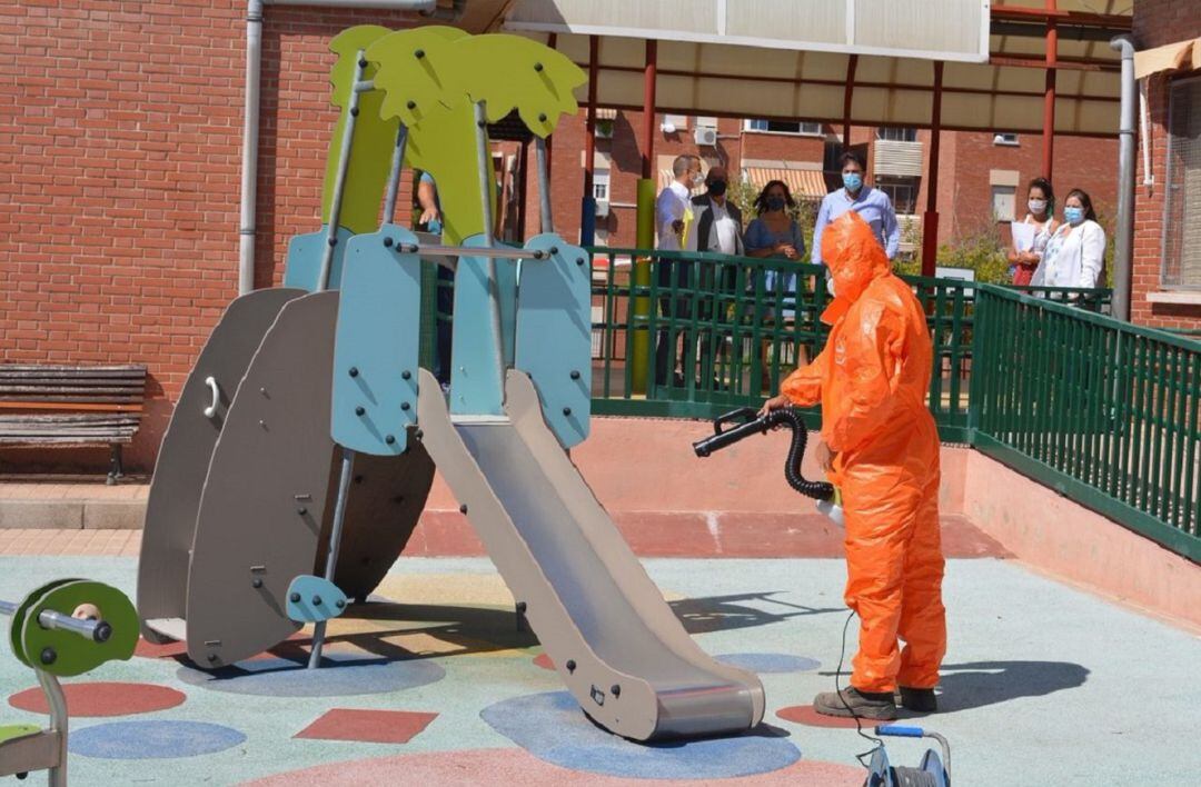 Un operario de la contrata de limpieza desinfecta unos juegos infantiles en un colegio