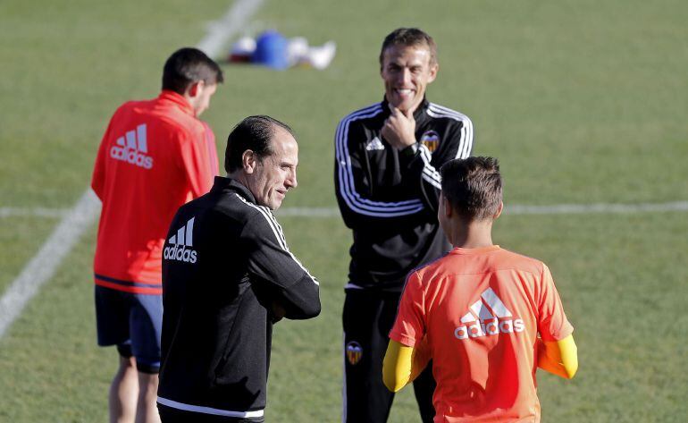 GRA016. PATERNA (VALENCIA), 04122015.- El entrandor provisional del Valencia CF, Salvador González Marco 'Voro' (2i, de espaldas), y el segundo técnico Phil Neville (2d), conversan con uno de sus jugadores durante el entrenamiento que han realizado esta mañana previo al partido de liga que les enfrentará mañana sábado al FC Barcelona. EFE Manuel Bruque