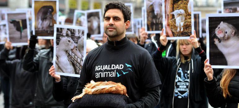 Several hundred activists of pro animal rights group "Igualdad Animal" (Animal Equity) hold dead animals and photos of animals as the organisation celebrates the International Animals Rights Day at Puerta del Sol Square in Madrid on December 13, 2014. AFP PHOTO/ GERARD JULIEN