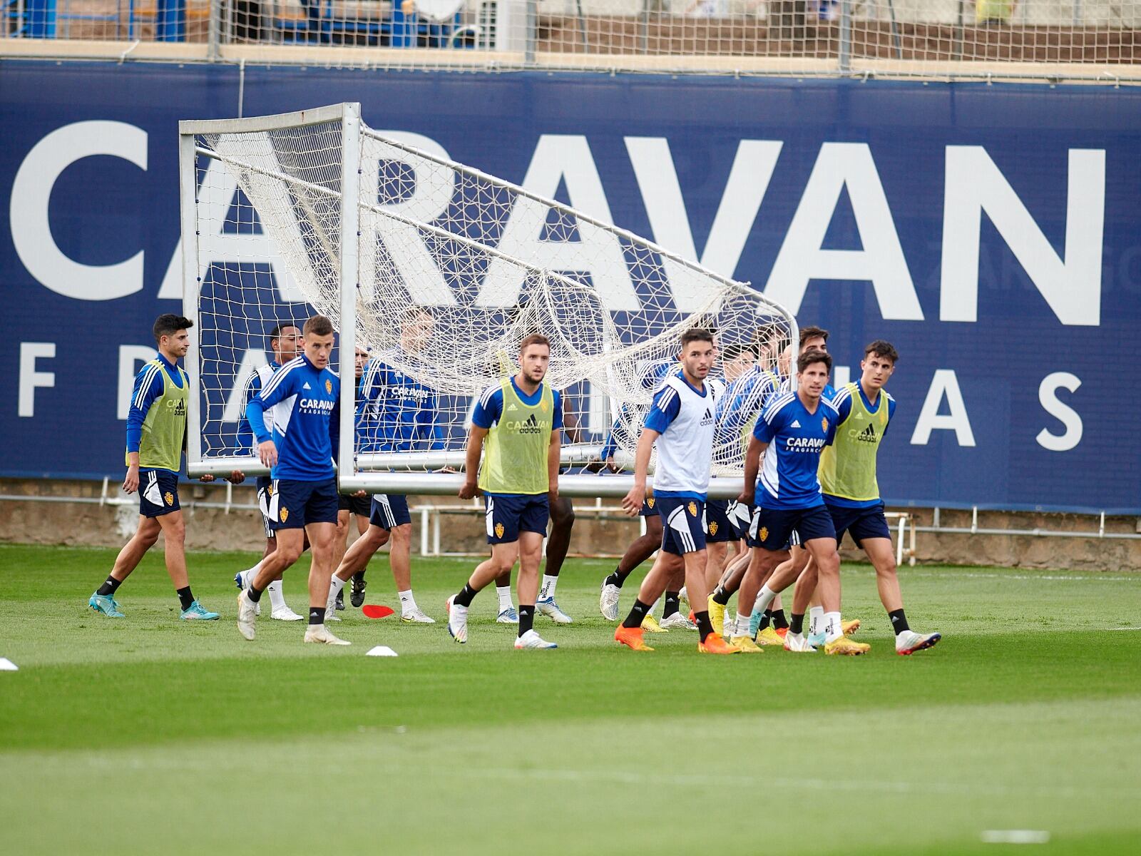 Los jugadores trasladan una portería de entrenamiento en la Ciudad Deportiva