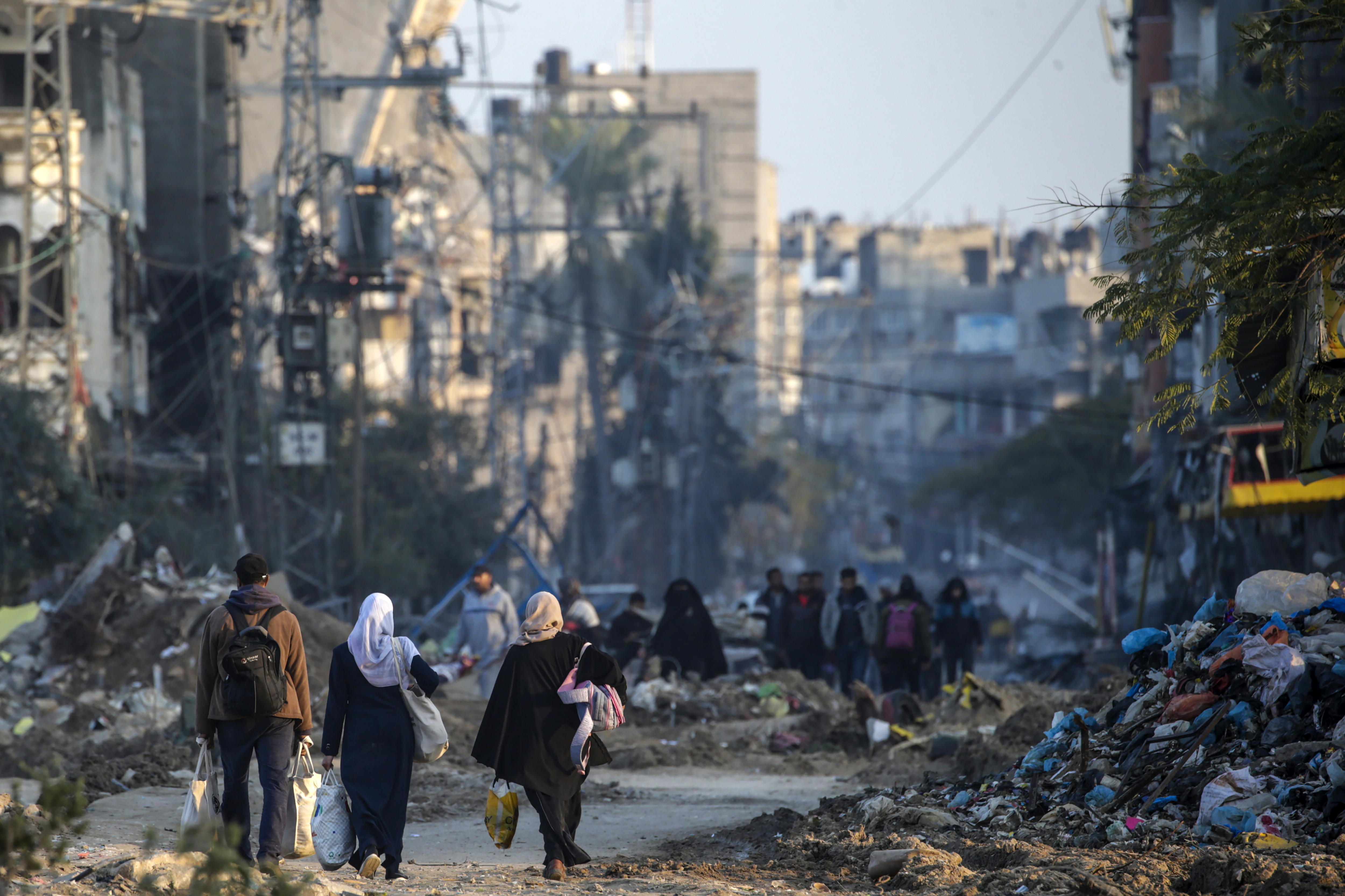 Personas caminan por los restos de la destrucción en Gaza