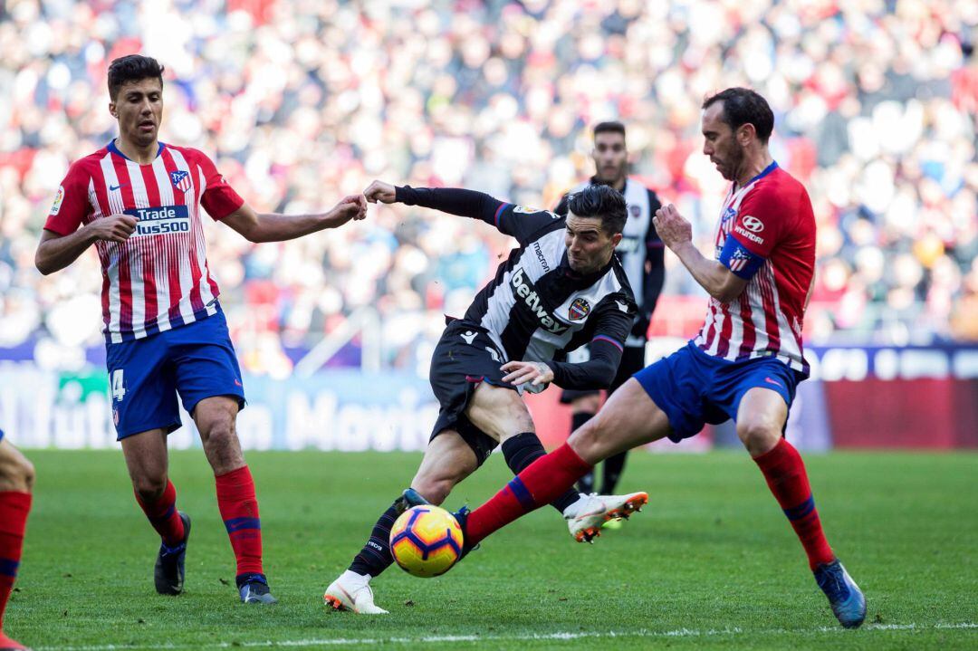 GRAF8124. MADRID, El delantero del Levante David Remeseiro (c) dispara a puerta ante los jugadores del Atlético de Madrid Diego Godín y Rodrigo Hernández durante el partido de la décima novena jornada de Liga de Primera División disputado esta mañana en el Wanda Metropolitano. EFE, Rodrigo Jiménez