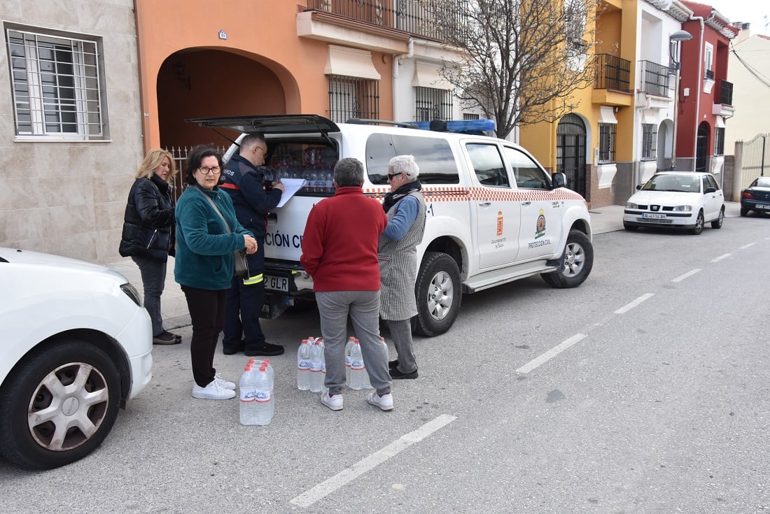 Reparto de agua embotellada a la población en Baza