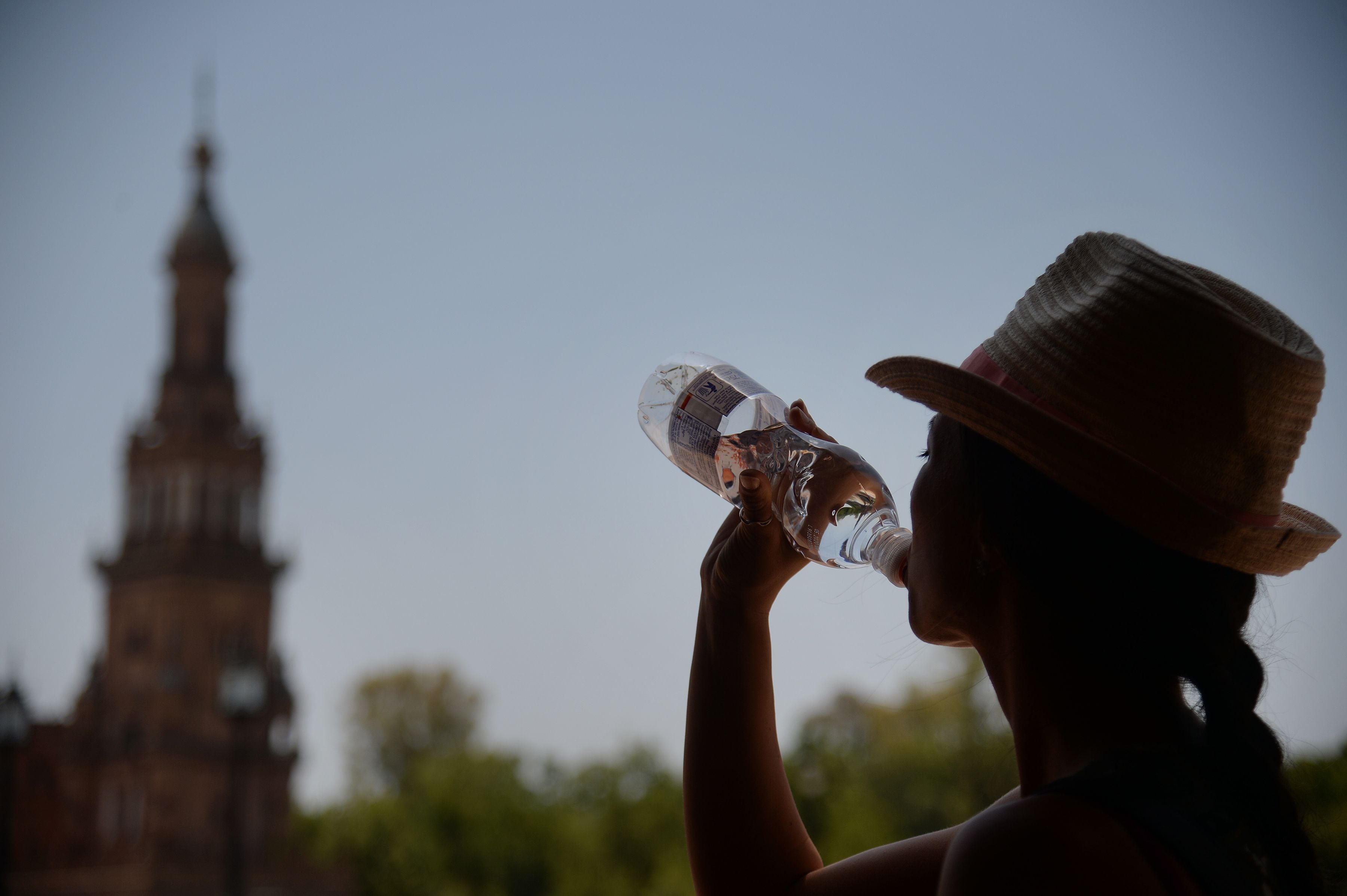 Una mujer bebe agua en un día caluroso en Sevilla.