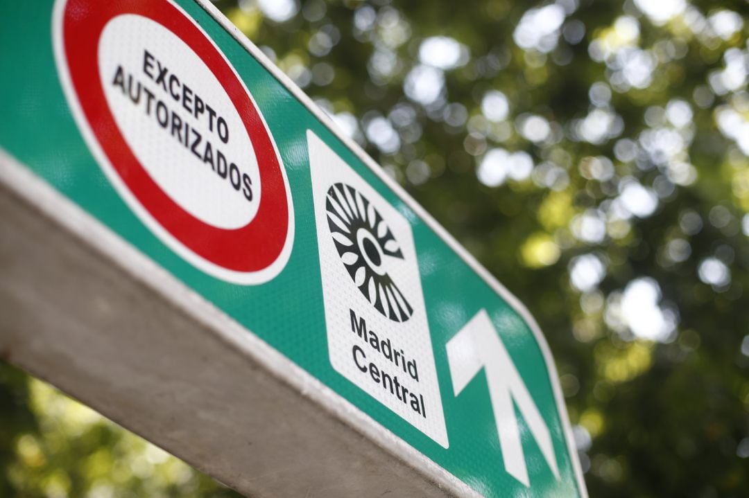 Señal con símbolo de prohibido aparcar al lado del distintivo de Madrid Central.