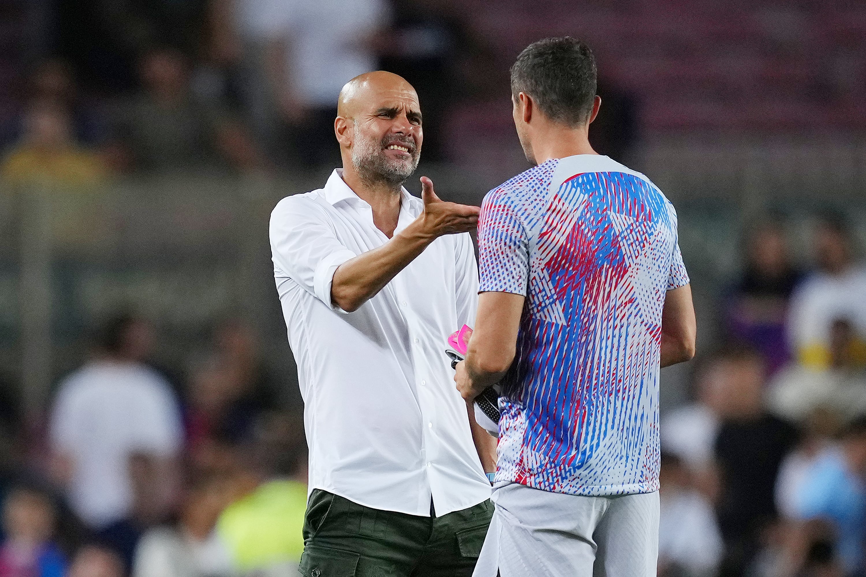 Pep Guardiola habla con Robert Lewandowski tras un partido entre el Barça y el City