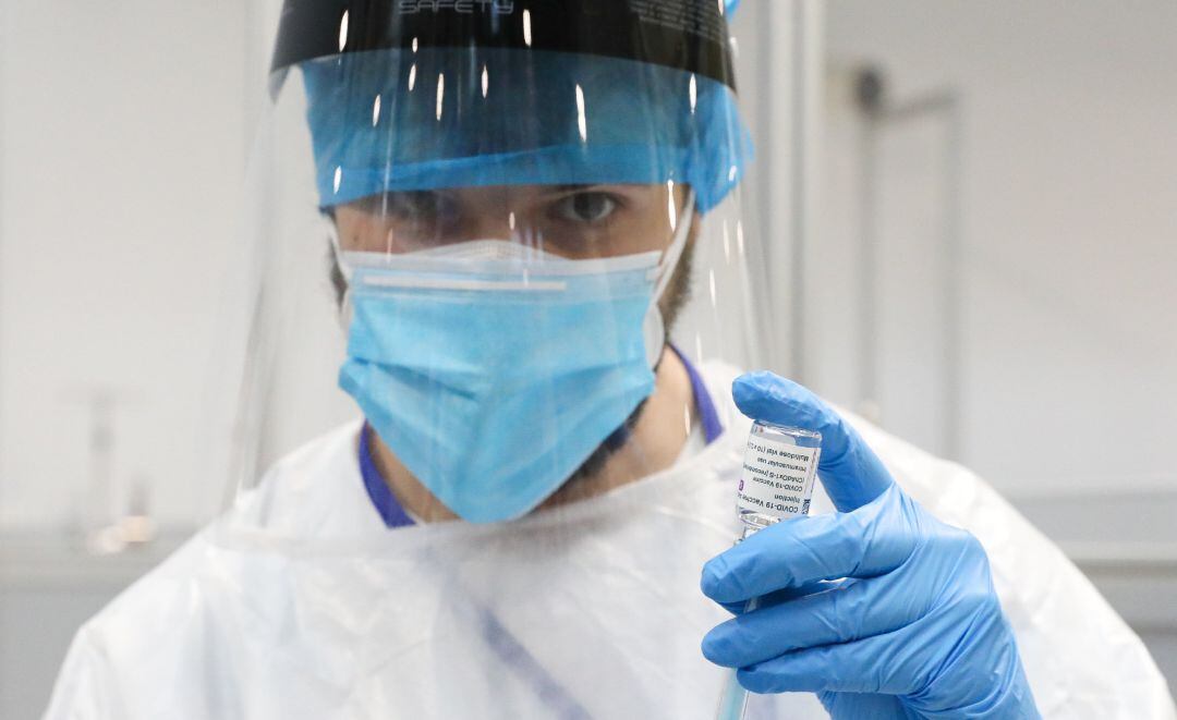 Un profesional sanitario sostiene un frasco con la vacuna contra el COVID-19 de AstraZeneca.