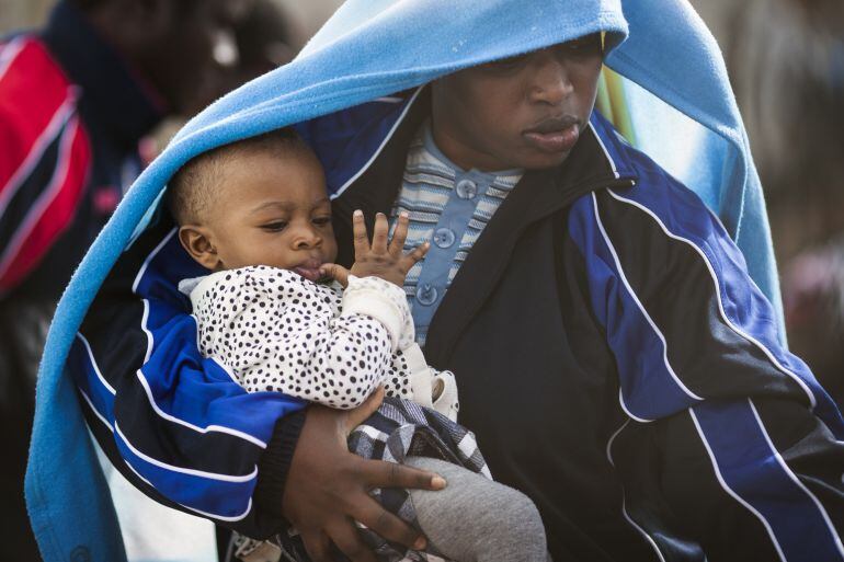 LAMPEDUSA, ITALY - APRIL 23:  A migrant woman and a young child board a ship bound for Sicily on April 23, 2015 in Lampedusa, Italy. It is expected that EU leaders in Brussels are to agree later that only 5,000 resettlement places across Europe are to be 