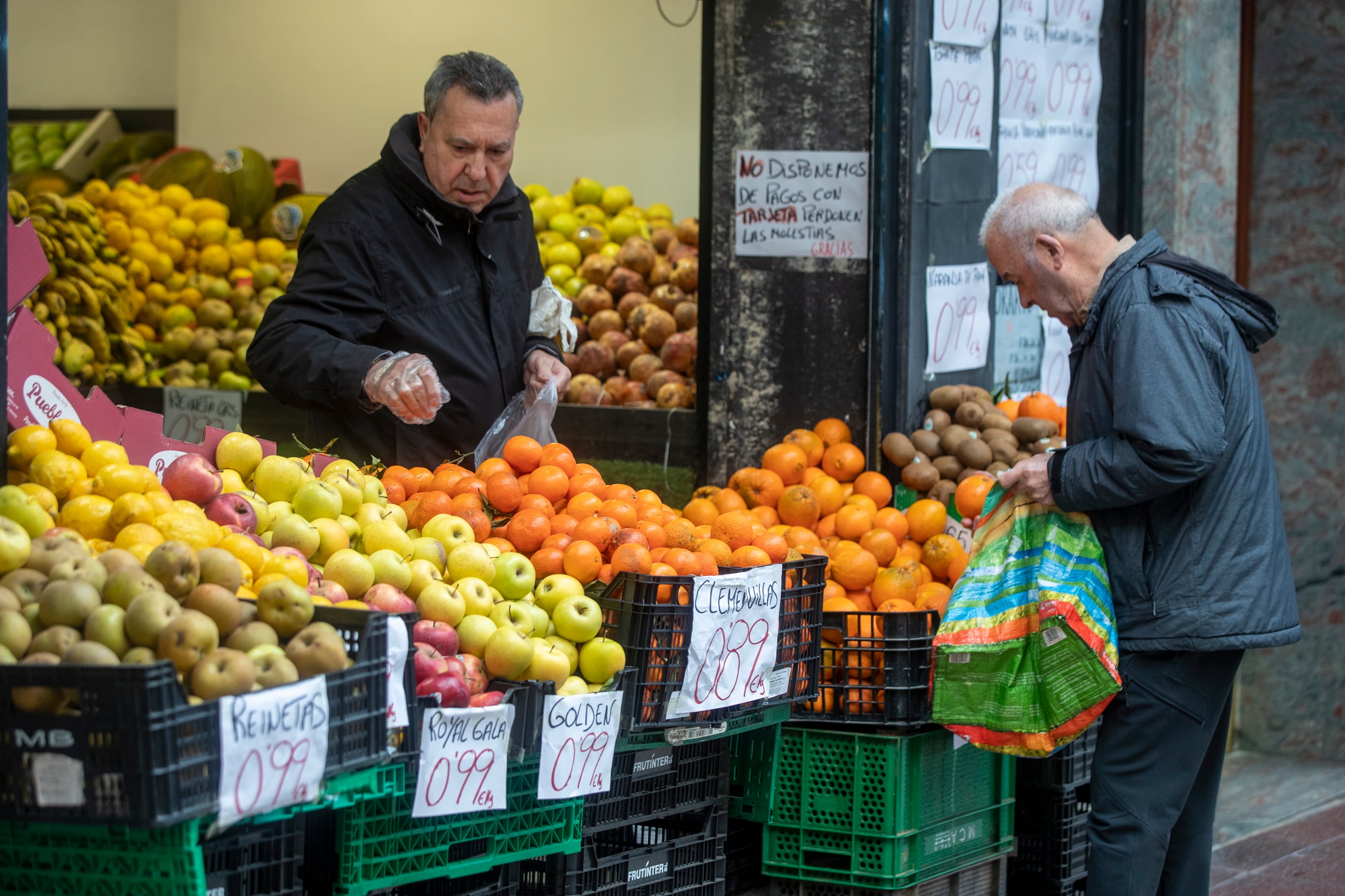 Varios clientes compran en una frutería de Vitoria.