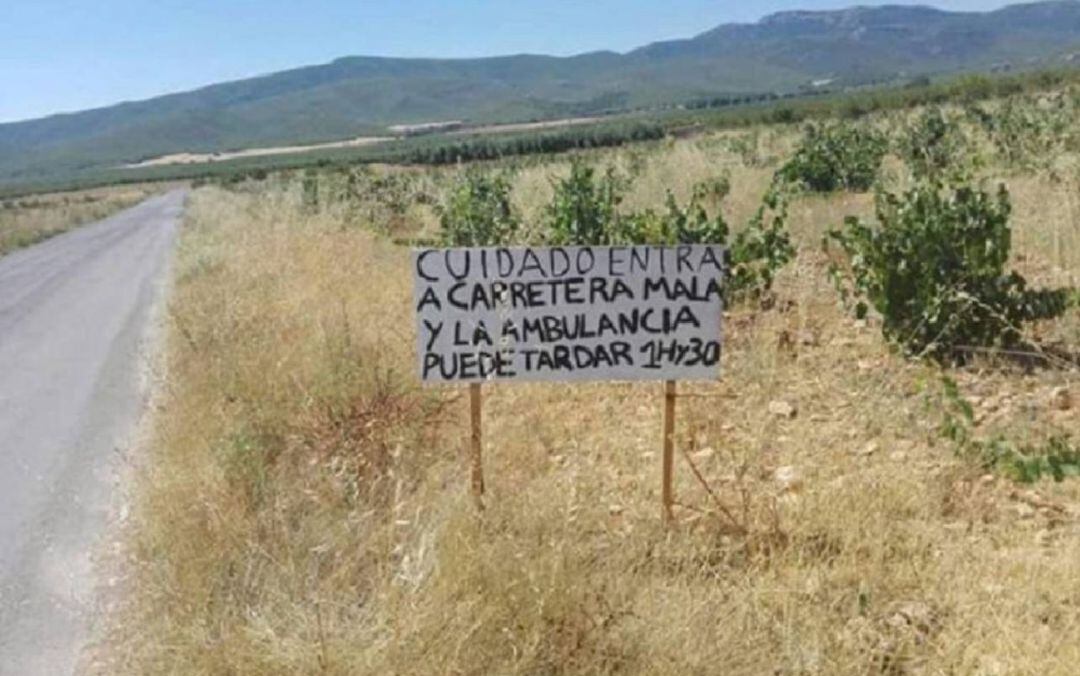 Un cartel colocado por los vecinos de Benizar (Moratalla) alerta a los conductores del estado de la carretera