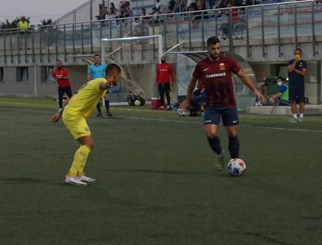 Mario Uclés controla el balón ante un defensor visitante