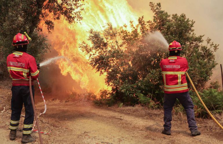 Dos bomberos portugueses durante el combate contra el fuego en Sandinha (Portugal).