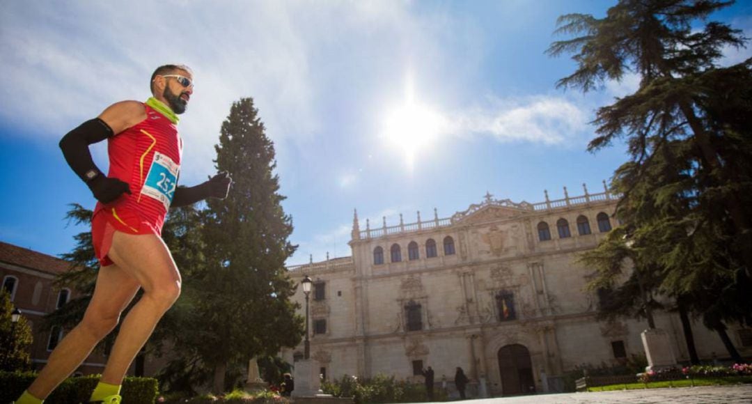 Un corredor frente a la fachada de la Universidad de Alcalá de Henares.