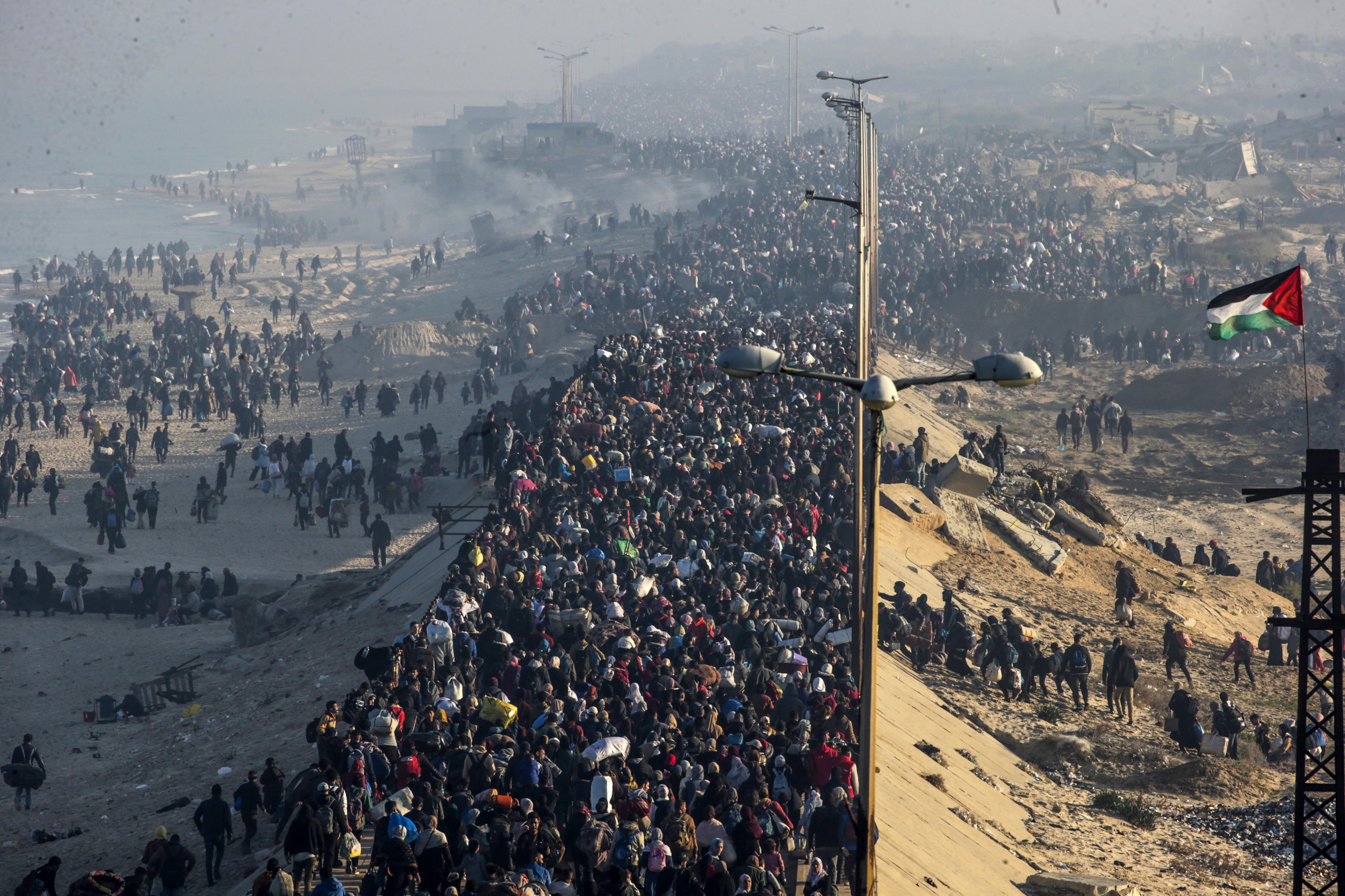 Palestinos desplazados caminan por la carretera de la costa del sur al norte de Gaza.