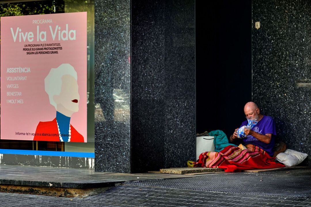 Un hombre sin hogar se prepara la cena en una calle del centro de Barcelona este jueves, sexagésimo octavo día del estado de alarma por la crisis del coronavirus.