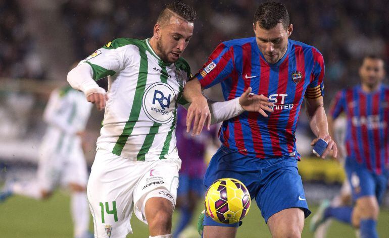 El defensa del Levante, David Navarro lucha el balón con el argelino Nabil Ghilas.