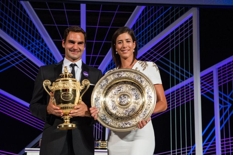 Muguruza posa junto a Federer mientras ambos sostienen sus trofeos de Wimbledon