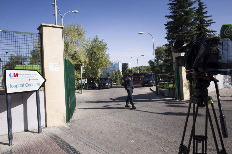 GRA079. MADRID, 25/10/2014.- Un agente de la Policía Nacional y algunos medios de comunicación a las puertas del Hospital Carlos III de Madrid, donde continúa ingresada Teresa Romero, la auxiliar de enfermería curada de ébola. El próximo lunes serán dados