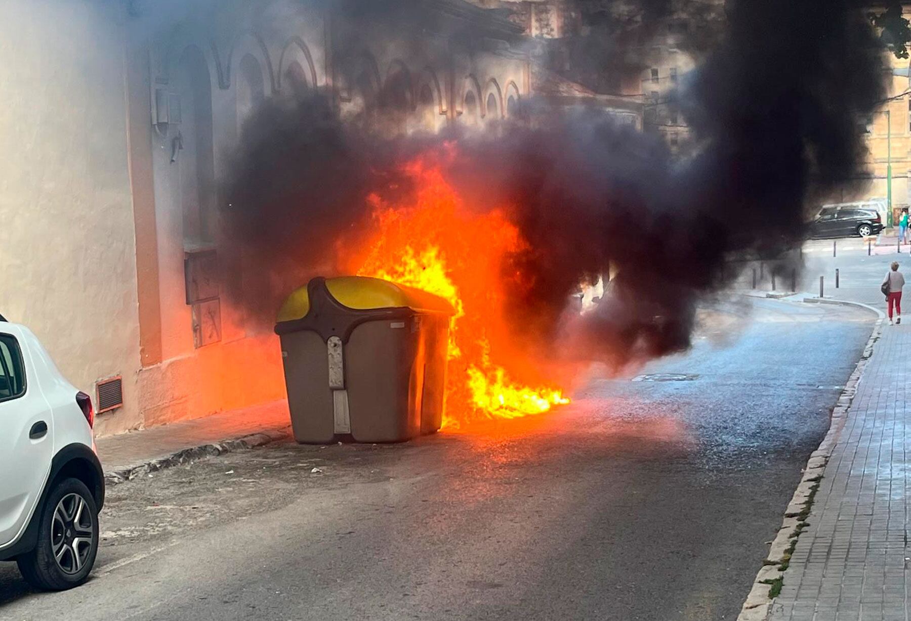 El contenedor en el momento de arder ubicado en la calle Quevedo junto a la plaza Gonzalo Cantó