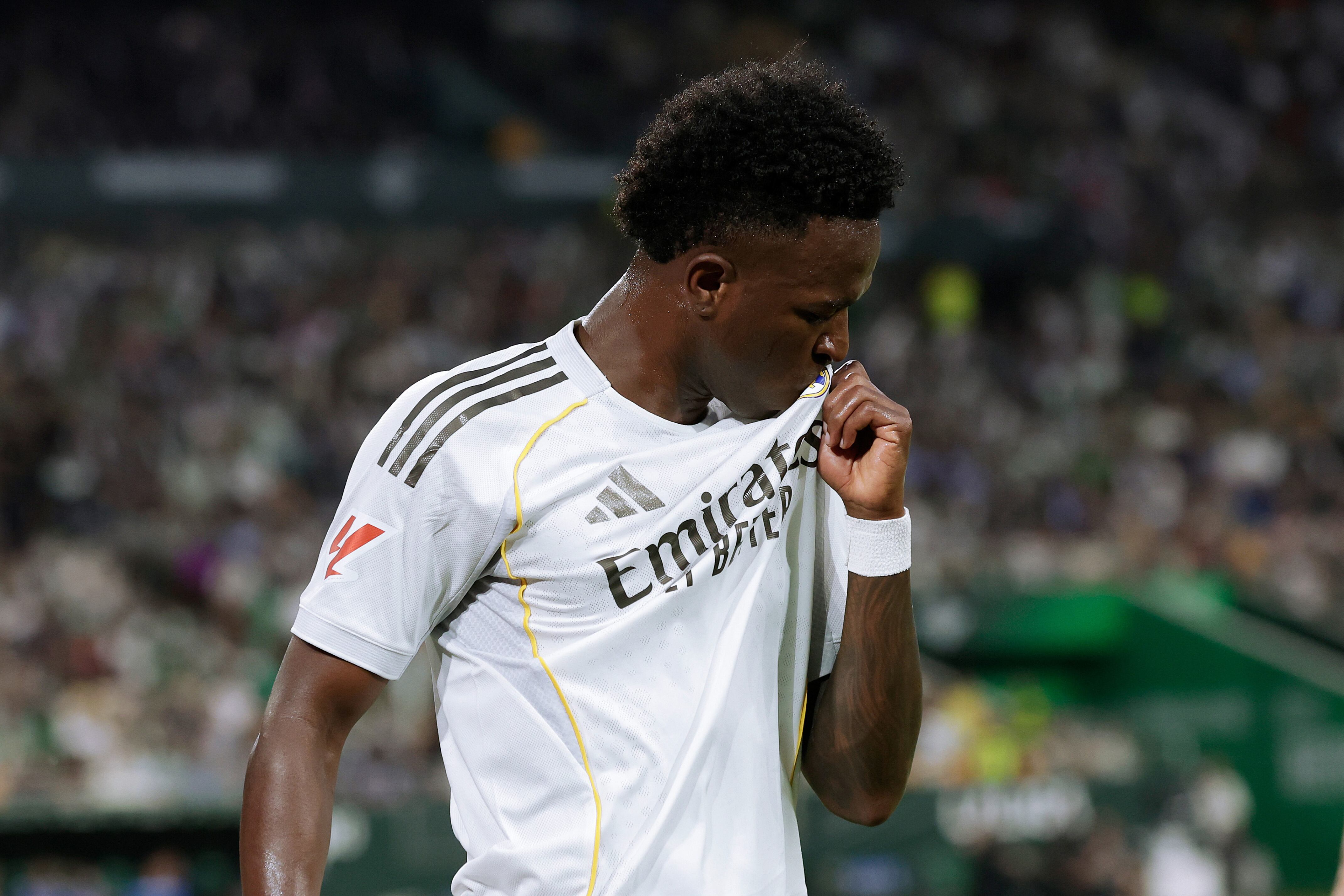 Vinicius celebra su gol contra el Real Betis besando el escudo (Photo by Eric Verhoeven/Soccrates/Getty Images)