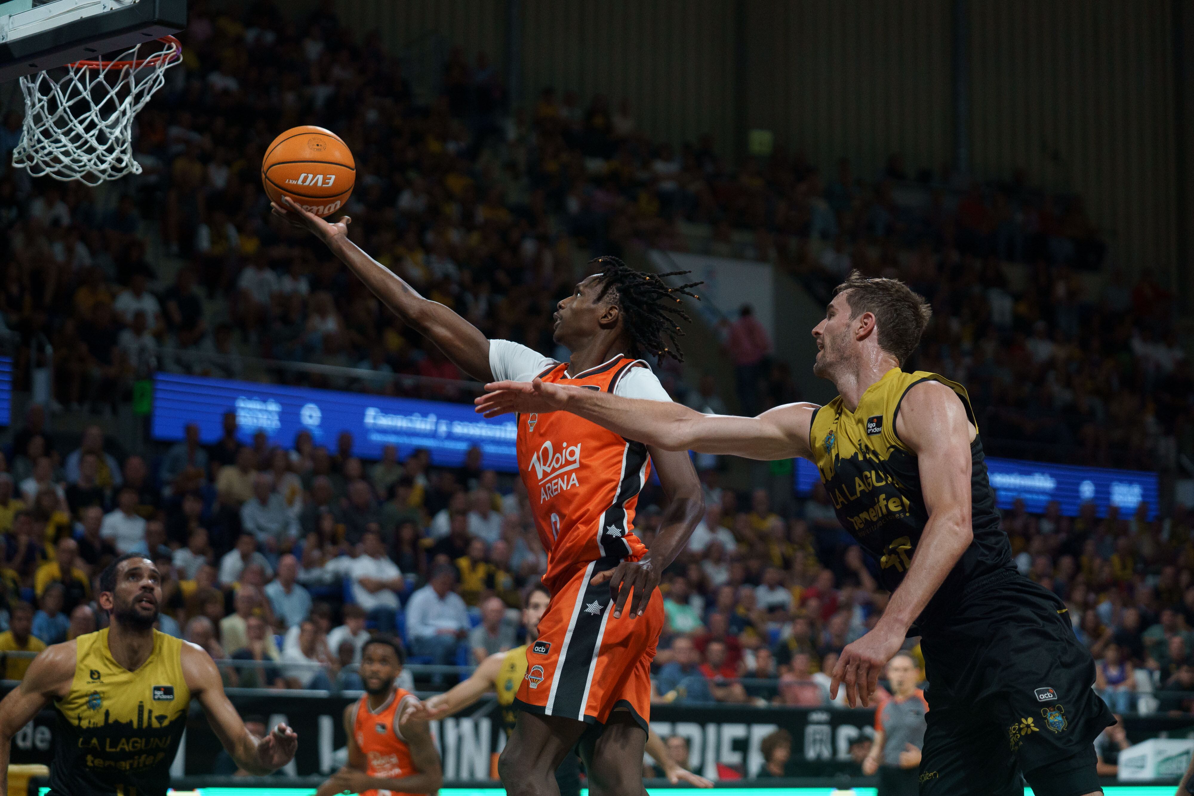 SANTA CRUZ DE TENERIFE, 14/06/2025.- El escolta del Valencia Brancou Badio (c) entra a canasta ante Aaron Doornekamp (d), del Tenerife, durante el tercer partido de las semifinales de la Liga Endesa de baloncesto que La Laguna Tenerife y Valencia Basket disputan este sábado en el pabellón Santiago Martín de La Laguna, en Tenerife. EFE/Ramón de la Rocha
