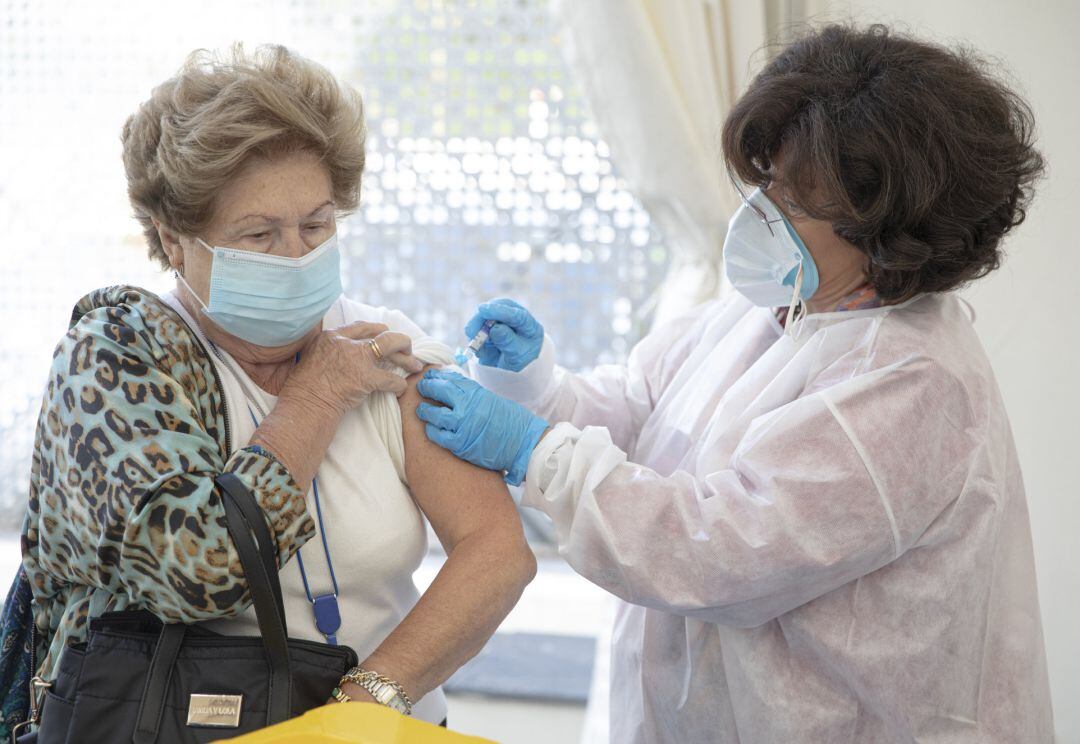 Una mujer se vacuna contra la gripe en el Colegio de Médicos de Sevilla que acoge mediante un convenio con el SAS.