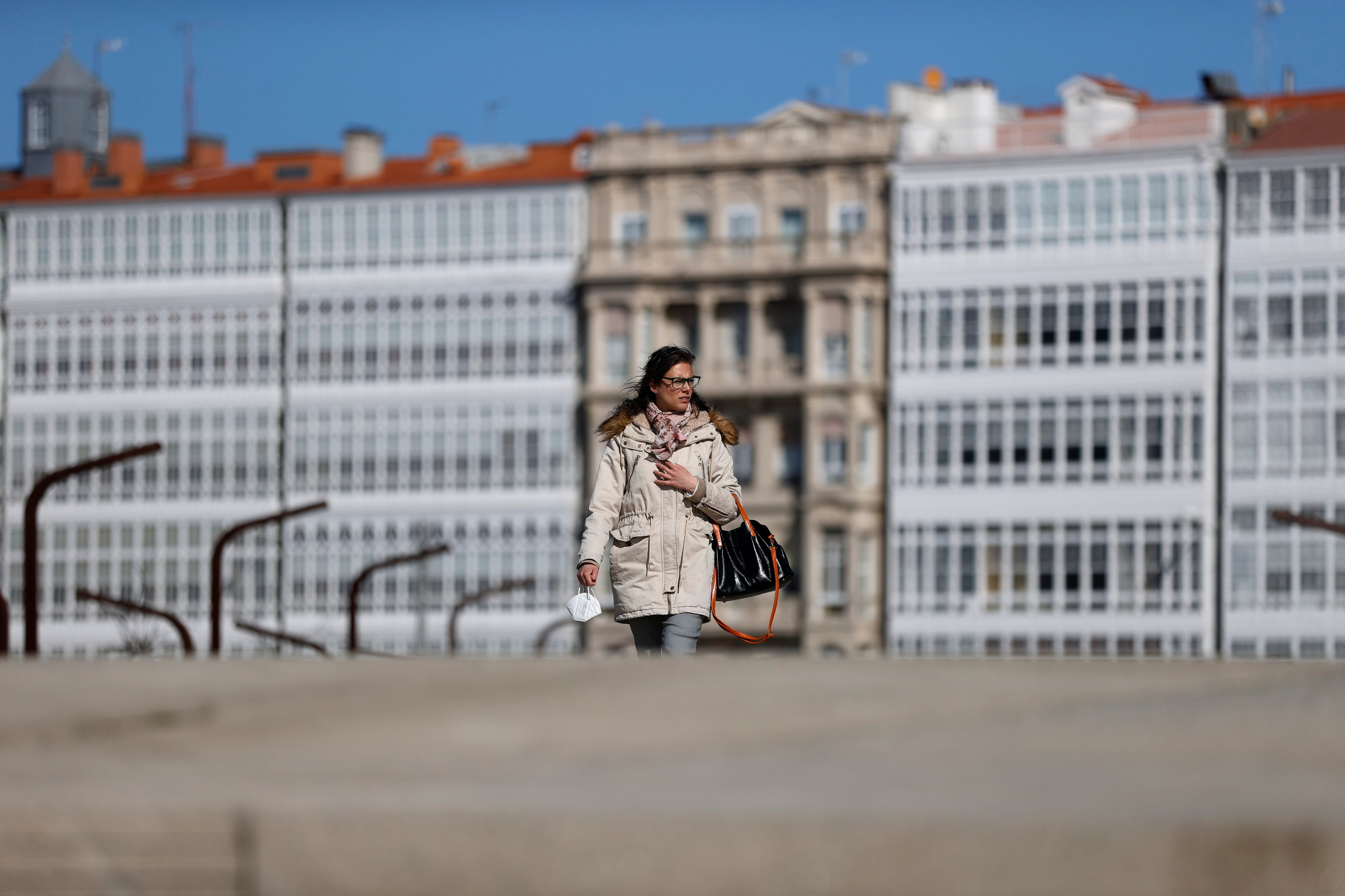 A CORUÑA, 17/03/21.- Una mujer camina este jueves por las calles de A Coruña, en una jornada en la que la AEMET ha informado en rueda de prensa del balance meteorológico del pasado invierno y de la predicción para el próximo trimestre. EFE/Cabalar