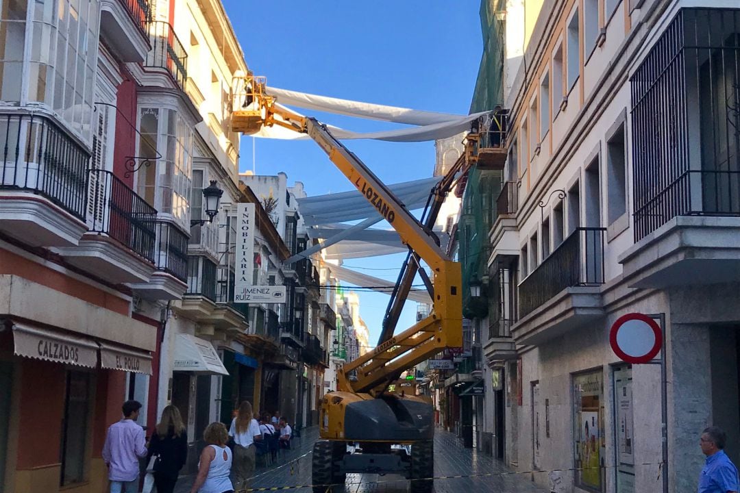 Labores de instalación de toldos, a primera hora de hoy, en la calle Luna