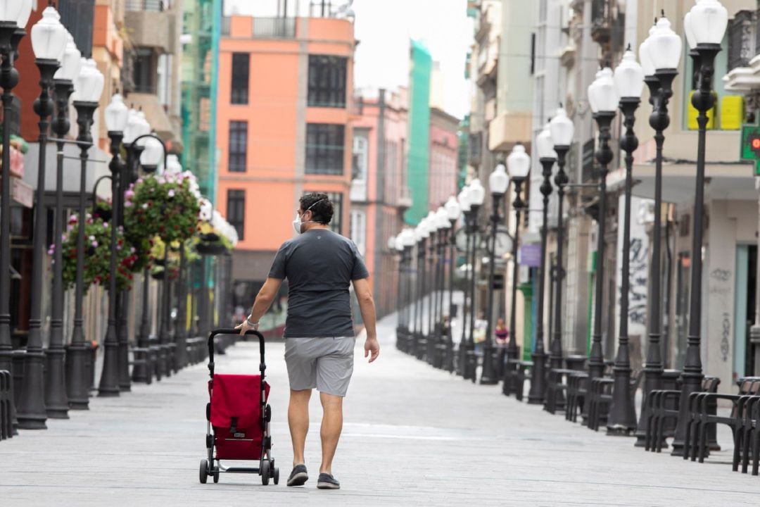 Un hombre camina este miércoles por la desierta calle de Triana, en Las Palmas de Gran Canaria, uno de las zonas de ocio y comercio más importantes de la ciudad.