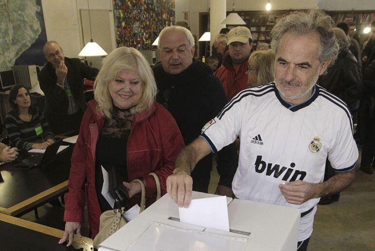 Un ciudadano, vestido con la camiseta del Real Madrid, deposita su papeleta en el Institut Montserrat de Barcelona