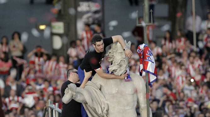 El capitán del Atlético de Madrid, Antonio López, celebra en lo alto de la fuente de Neptuno la victoria en la final de la Liga Europa, el 10 de mayo de 2012, después de ganar en el último partido al Athletic Club de Bilbao el miércoles en el estadio naci