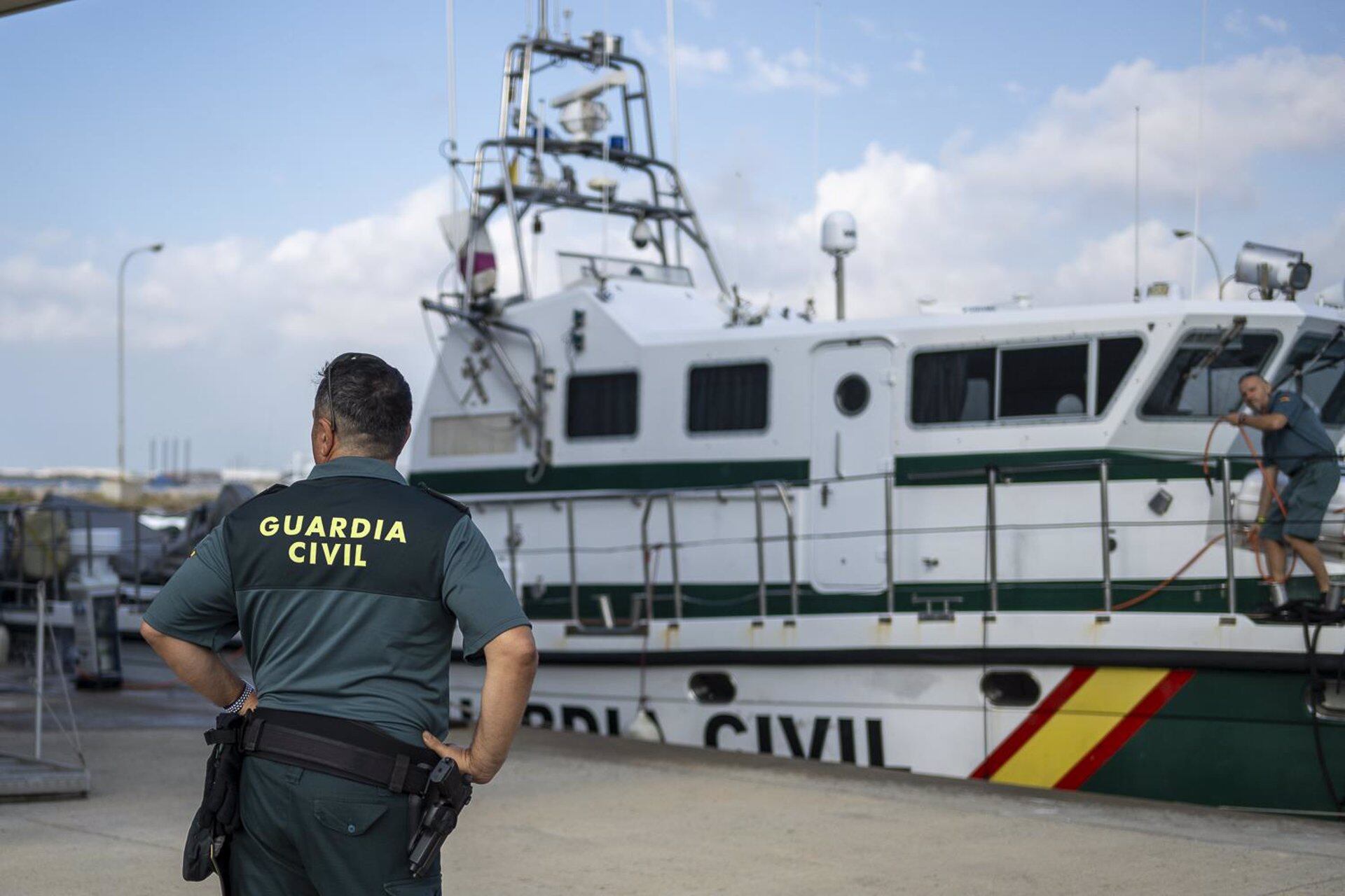 Un agente de la Guardia Civil delante de una patrulla marítima