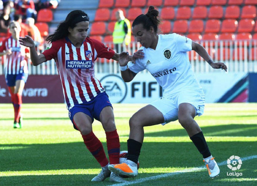 Lombi (derecha) intenta zafarse de la presión de un rival. 