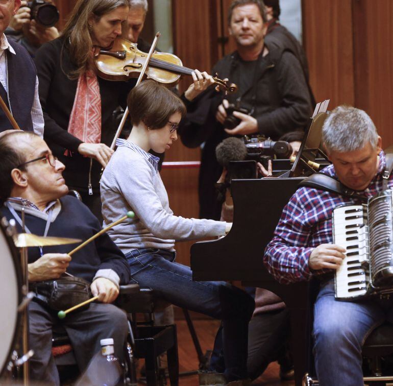 Varias personas con discapacidad preparan con la OSE un concierto. 