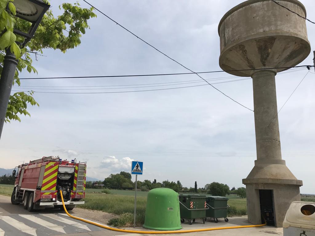 Camión de bomberos suministrando agua al depósito de Banariés