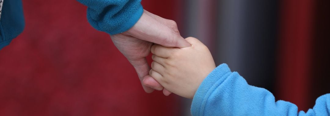 Un niño camina de la mano