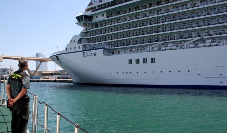 Un agente de la Guardia Civil observa la entrada de un crucero al puerto de Barcelona. 