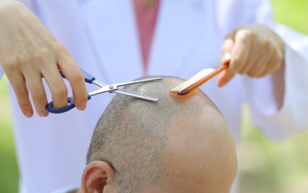 Un hombre cortándose el pelo.