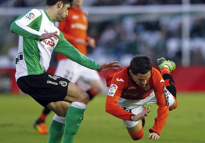 El centrocampista argentino del Valencia Pablo Piatti cae ante el defensa del Racing de Santander Álvaro González durante el encuentro correspondiente a la vigésimo primera jornada de la Liga BBVA.