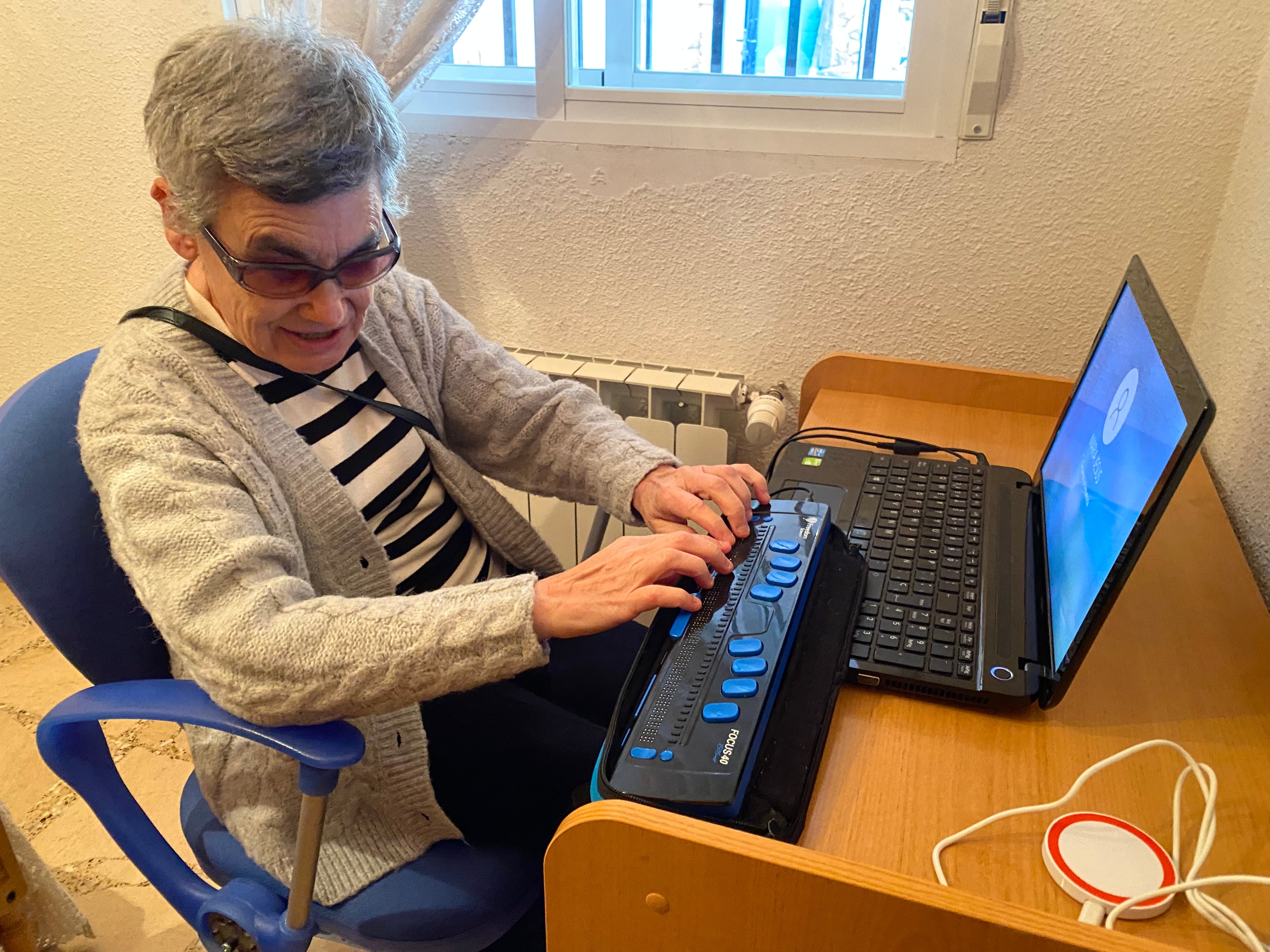 María Jesús Cañamares en su casa de Jábaga con su ordenador y teclado de braille.