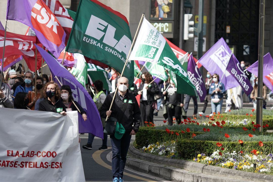 Un grupo de personas participa con pancartas y banderas en una manifestación de trabajadores de los servicios públicos vascos