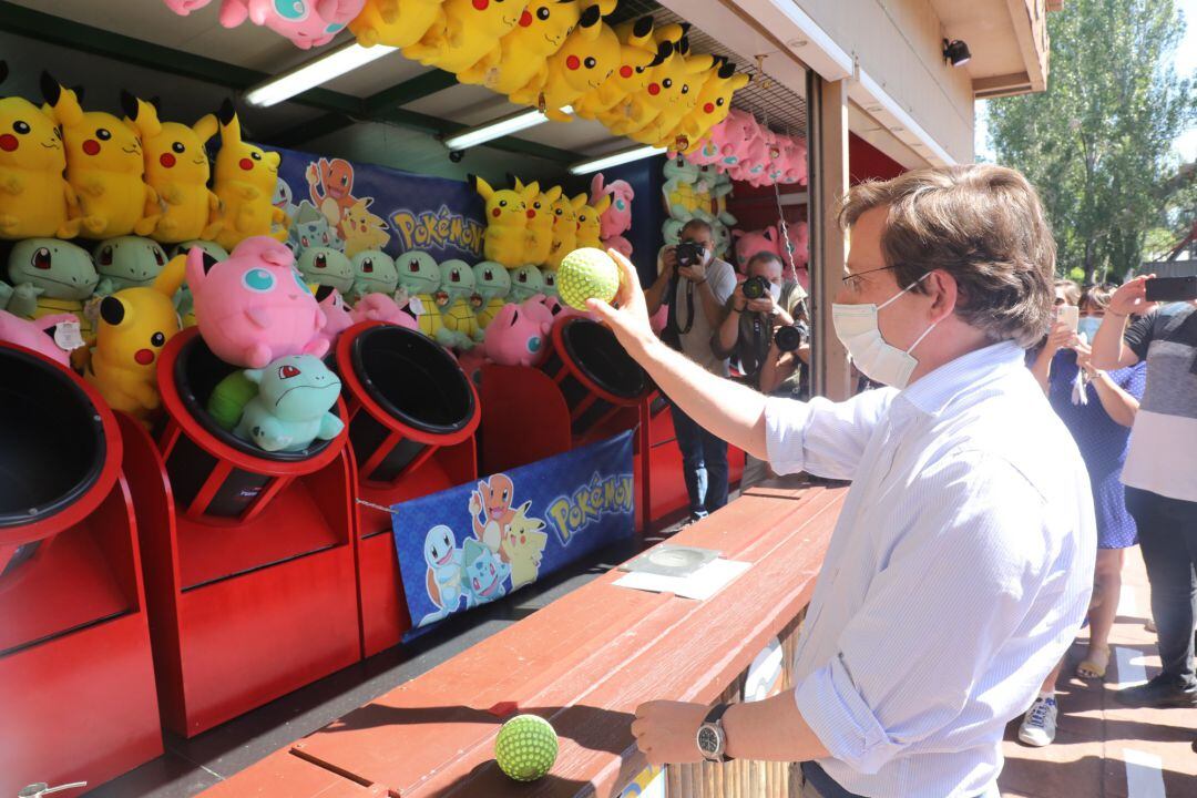 El alcalde de Madrid, José Luis Martínez-Almeida, juega con una pelota en un puesto del Parque de Atracciones durante su visita el día en el que visita también el Zoo y el Teleférico ante la reapertura de estas instalaciones.